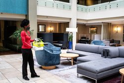 Woman Sanitizing Hotel Atrium Couch